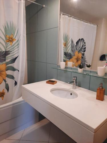 a bathroom with a sink and a shower curtain at vila verde twonhouse T54 in Santa Maria