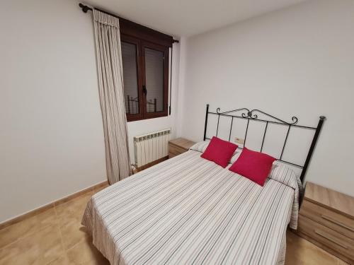 Un dormitorio con una cama grande con dos almohadas rojas. en LA TERRAZA, en Teruel
