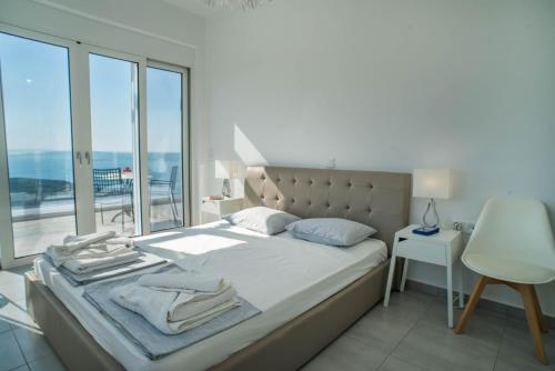 a bedroom with a bed with a view of the ocean at Villa Cassandra - A breathtaking view of Souda-Chania bay and the White Mountains in Kókkinon Khoríon