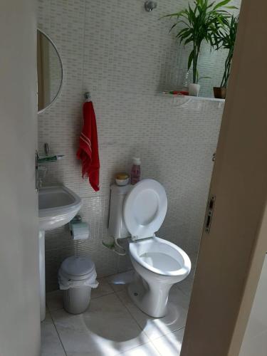 y baño con aseo blanco y lavamanos. en Apartamento Atobá, en Florianópolis