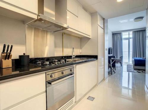 a large kitchen with a stove and a sink at Brand New Studio in Artesia in Damac Hills in Dubai