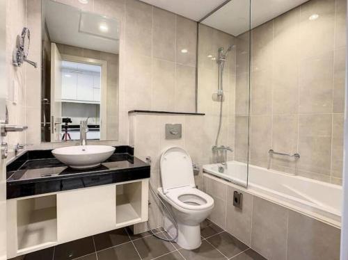 a bathroom with a toilet and a sink and a shower at Brand New Studio in Artesia in Damac Hills in Dubai