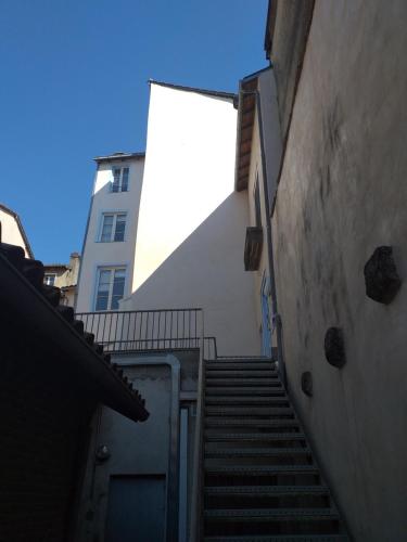 un escalier menant à un bâtiment avec un escalier en arrière. dans l'établissement Studio tout équipé plein centre-ville de Limoges, à Limoges