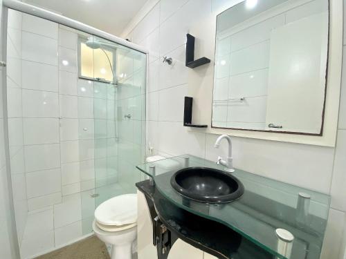 y baño con lavabo, aseo y espejo. en Loft em Bombas - Excelente Localização - 1 dorm 3 pessoas, en Bombinhas