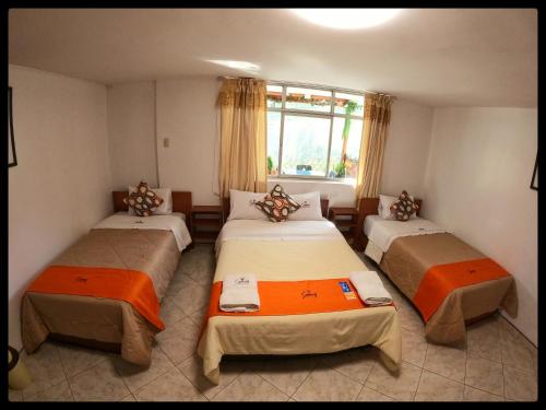 a room with three beds and a window at Sumaq Dreams Ayacucho in Ayacucho