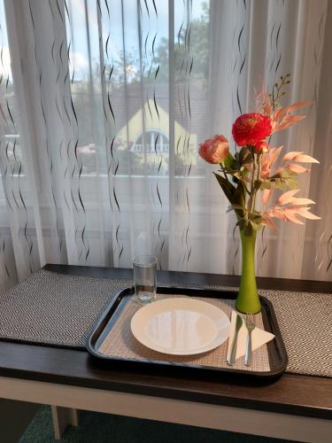 a tray with a plate and a vase with flowers at Summer House emeleti szoba in Debrecen
