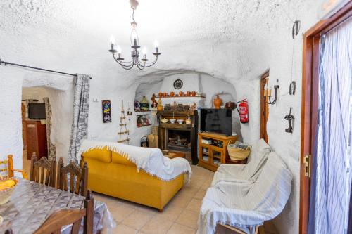 a living room with a yellow couch and a table at Casa cueva con encanto in Terque