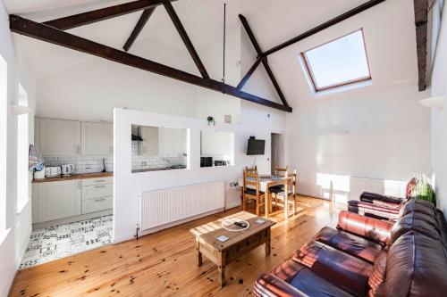 a living room with a couch and a table at The Old Bakery - Norfolk Holiday Properties in Great Yarmouth