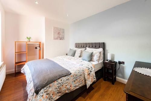 een slaapkamer met een groot bed en een houten vloer bij The Old Bakery - Norfolk Holiday Properties in Great Yarmouth