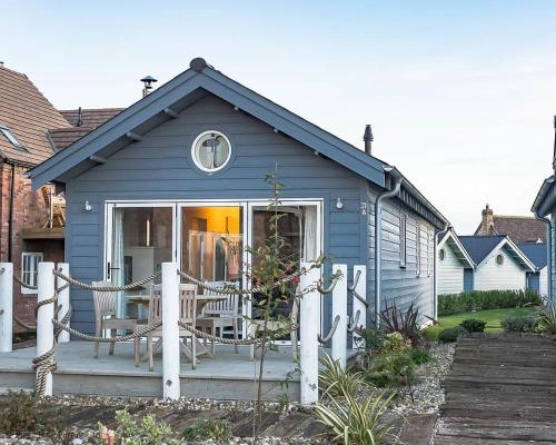 a blue house with chairs on a porch at Mariners, The Bay, 2 bedrooms with ensuites, parking nearby, 1 medium or 2 small dogs welcome in Filey