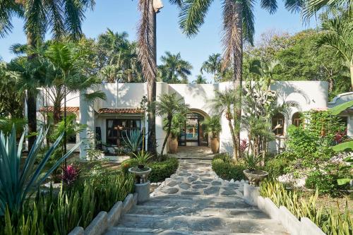 una casa con palmeras y una pasarela en Oceana - Beachfront Villa, en Mal País