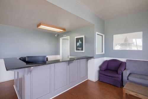 a kitchen with a counter and a purple chair at Americas Best Value Inn Lockhart TX in Lockhart