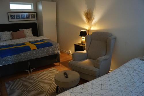 a bedroom with a bed and a chair and a bed and a chair at BRABO in Landskrona