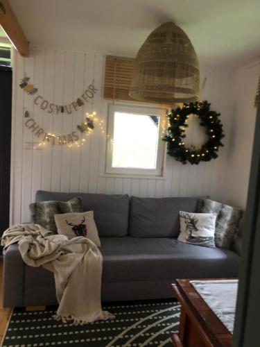 a living room with a blue couch and a wreath at Domek Pod Lasem in Trzciana
