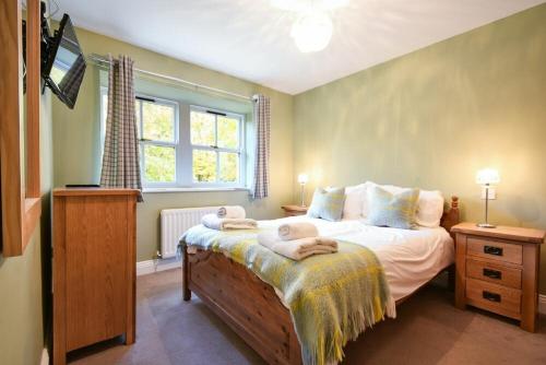 a bedroom with a bed and a window and a television at Chaffinch in Lucker