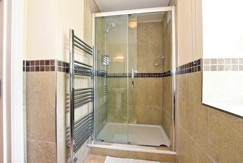 a shower with a glass door in a bathroom at Chaffinch in Lucker