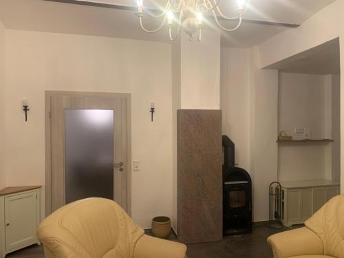 a living room with two chairs and a fireplace at Pension Gesundbrunnen in Müglitztal