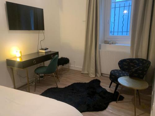 - une chambre avec un bureau, des chaises et un lit dans l'établissement Appartement velouté, à Dijon