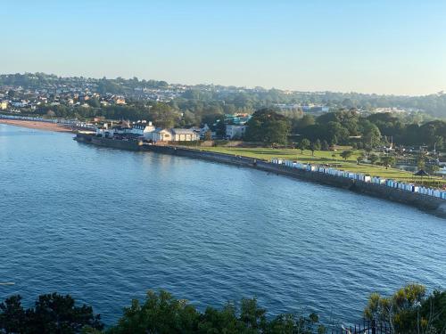a train is parked next to a river at Paignton Place in Marldon