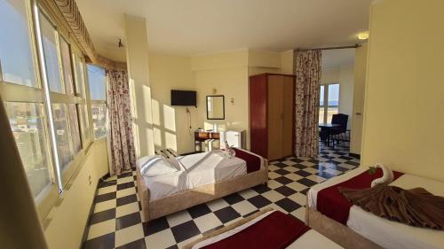 una camera d'albergo con un letto e un pavimento a scacchi di Royal City Hotel a Hurghada