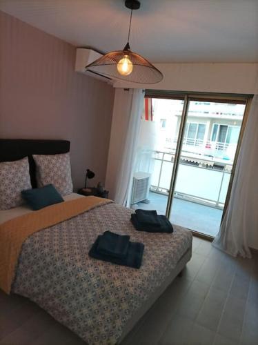 a bedroom with a bed with two black towels on it at EMPLACEMENT DE PREMIER ORDRE EN BAS DES PLAGES ET DES COMMERCES in Juan-les-Pins