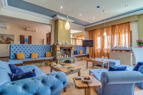 a living room with blue couches and a tv at Hotel Pegasus-Adult Friendly in Limenas