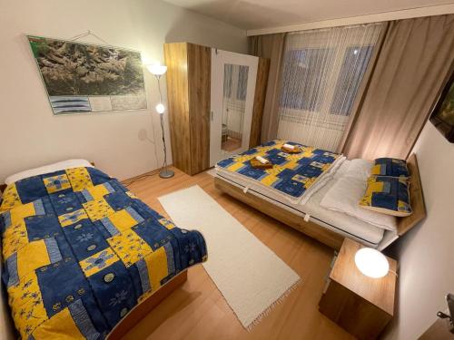a bedroom with two beds and a window at Apartmán DoMa - Tatranská Lomnica in Tatranská Lomnica