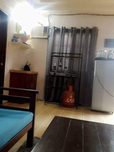 a living room with a black curtain and a refrigerator at JW Apartments in Angeles