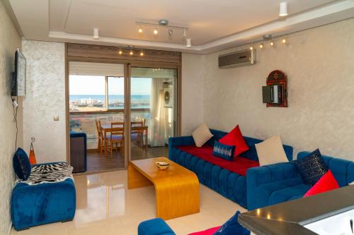 a living room with a blue couch and a table at PUERTO MARINA ASILAH in Asilah