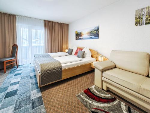 a hotel room with a bed and a couch at Partenerhof in Partenen