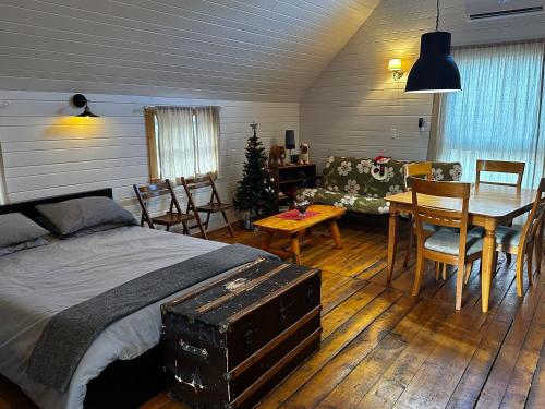 a bedroom with a bed and a table and a couch at House & loft, pool table, ping-pong, fireplace, AC in Ayer's Cliff