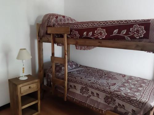 a bedroom with two bunk beds and a table at Raíces Departamento 1 in San Rafael
