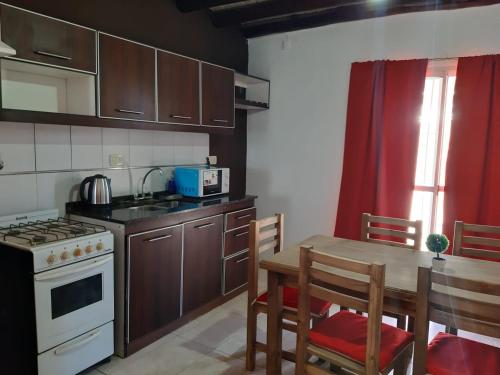 a kitchen with a table and a stove top oven at Raíces Departamento 1 in San Rafael