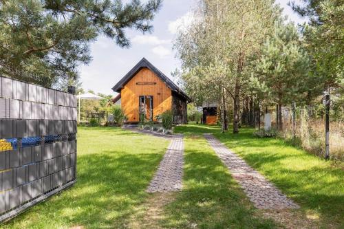 un granero con un camino delante de un patio en Ślusarnia-domek z sauną nad jeziorem, Kaszuby, en Żuromin