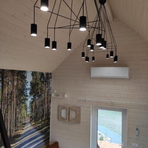 a room with a painting on the wall and lights at Ślusarnia-domek z sauną i balią nad jeziorem, Kaszuby in Żuromino