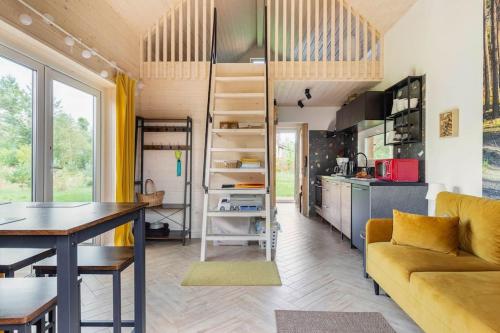 a tiny house with a kitchen and a living room at Ślusarnia-domek z sauną i balią nad jeziorem, Kaszuby in Żuromino