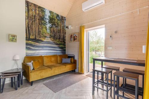 a living room with a couch and a painting on the wall at Ślusarnia-domek z sauną i balią nad jeziorem, Kaszuby in Żuromino