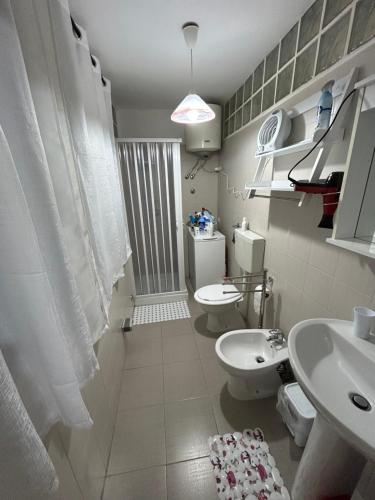 een badkamer met 2 toiletten, een wastafel en een douche bij Monolocale PIRILÙ in Reggio di Calabria