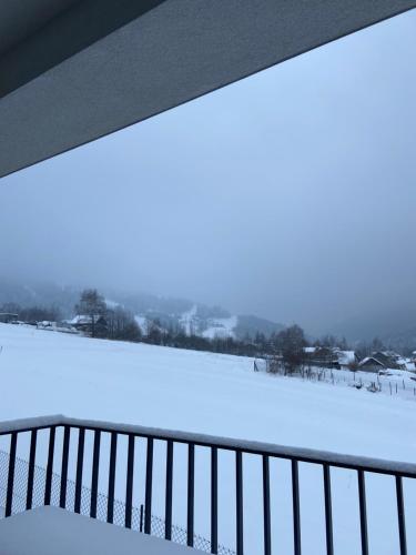 a view of a snow covered field from a balcony at Górski Apartament Olimpijska 1L in Szczyrk