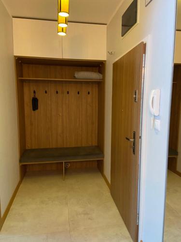 a room with a closet with a wooden door at Górski Apartament Olimpijska 1L in Szczyrk