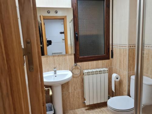 Un baño con lavabo, inodoro y espejo. en LA TERRAZA, en Teruel