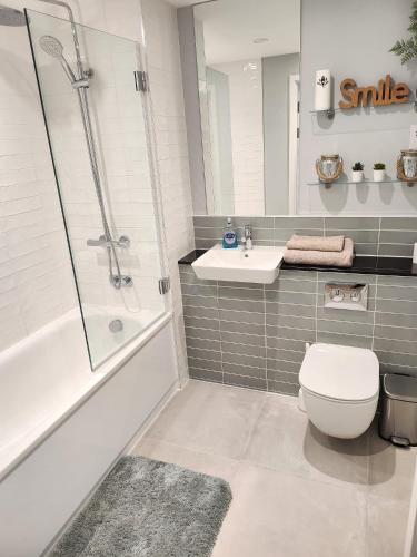 uma casa de banho com um chuveiro, um WC e um lavatório. em Lovely Luxury Apartment with Free Parking 209 em Luton