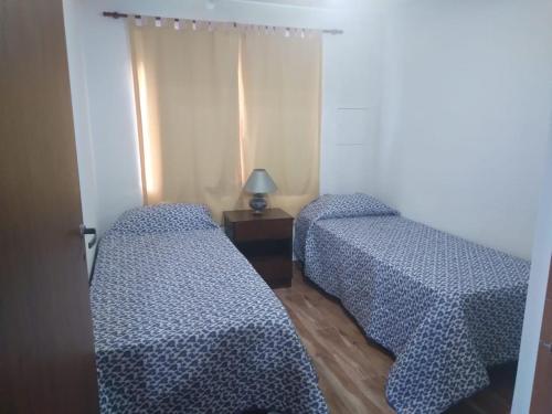 2 camas en una habitación con sábanas azules y blancas en Cabaña Doña Alicia en San Rafael