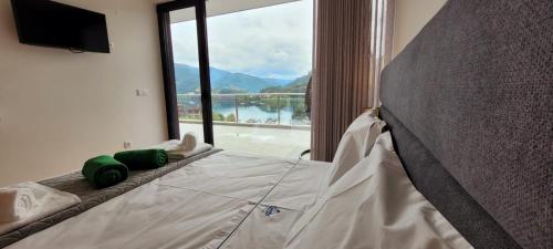 a bed with green pillows in a room with a window at Geresmarinahouse in Geres