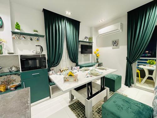 a kitchen with green curtains and a white table at Luxury Studio House 589-1 in 6th Of October