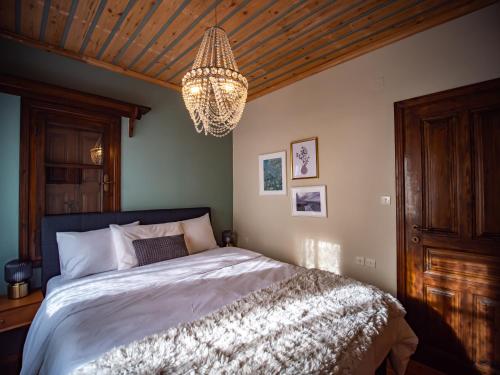 a bedroom with a bed and a chandelier at KP113 All Season Villa in Makrinitsa in Makrinítsa
