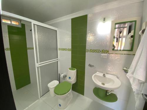 uma casa de banho verde e branca com um lavatório e um WC em Hotel Campestre Dorado SAI em San Andrés