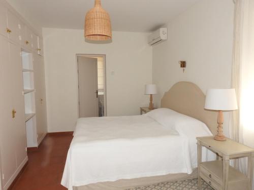 Un dormitorio blanco con una cama blanca y una lámpara en Casa con vistas a la Bahía de Cádiz, en El Puerto de Santa María