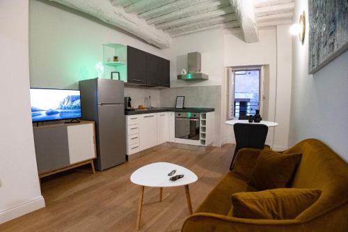 BF Glam-Apartments في بيروجيا: غرفة معيشة مع أريكة وطاولة ومطبخ