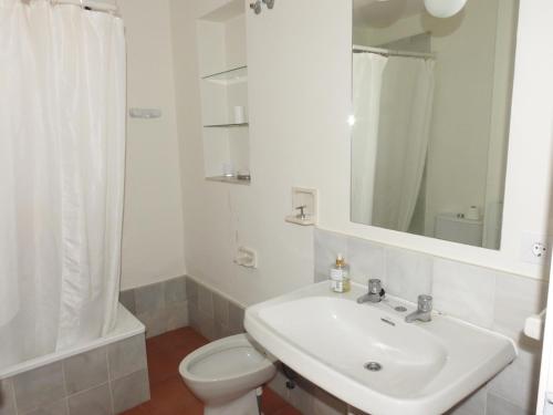La salle de bains blanche est pourvue d'un lavabo et de toilettes. dans l'établissement Casa con vistas a la Bahía de Cádiz, à El Puerto de Santa María